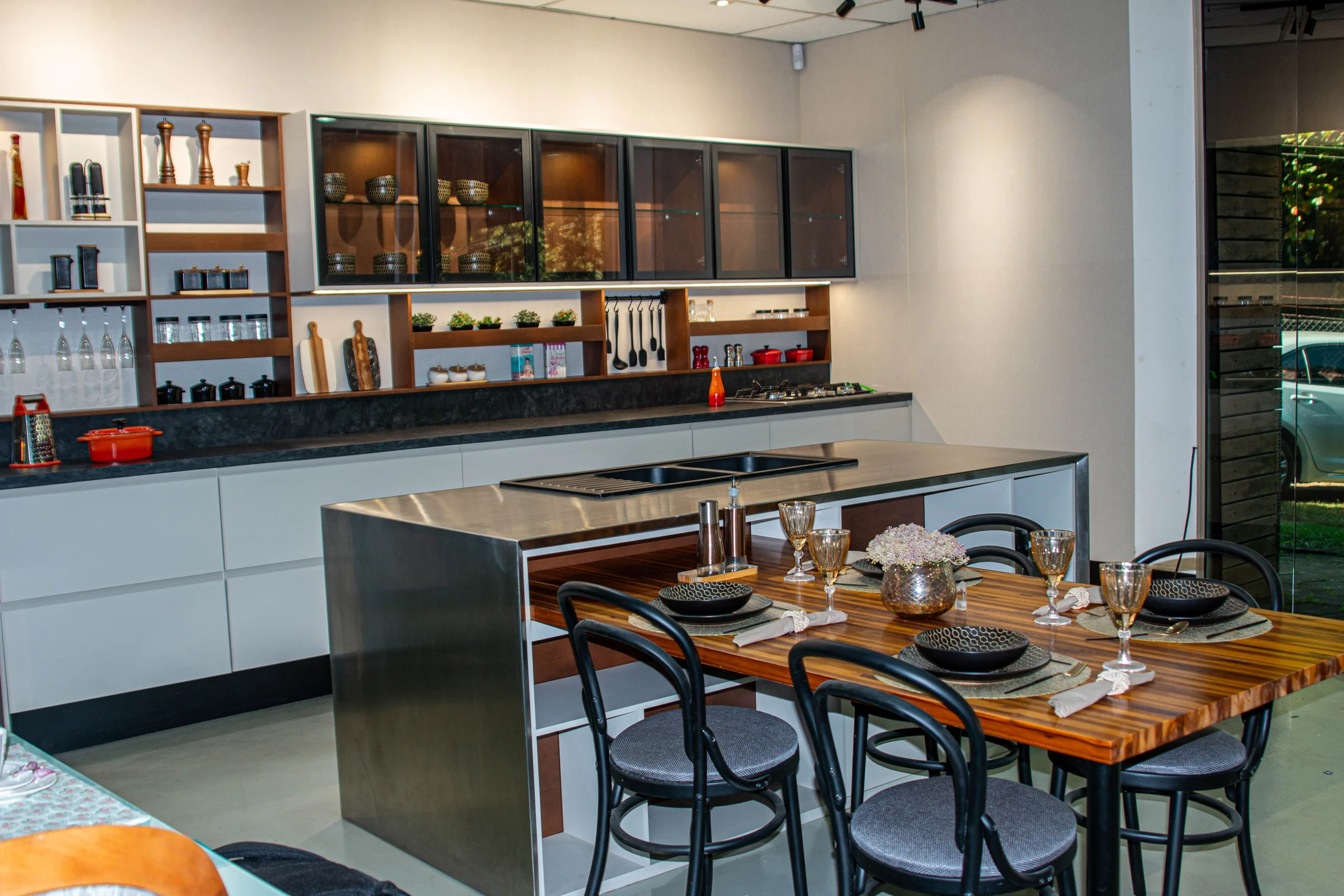 Ambiente SAXS com cozinha integrada, mesa de madeira e vista para o jardim